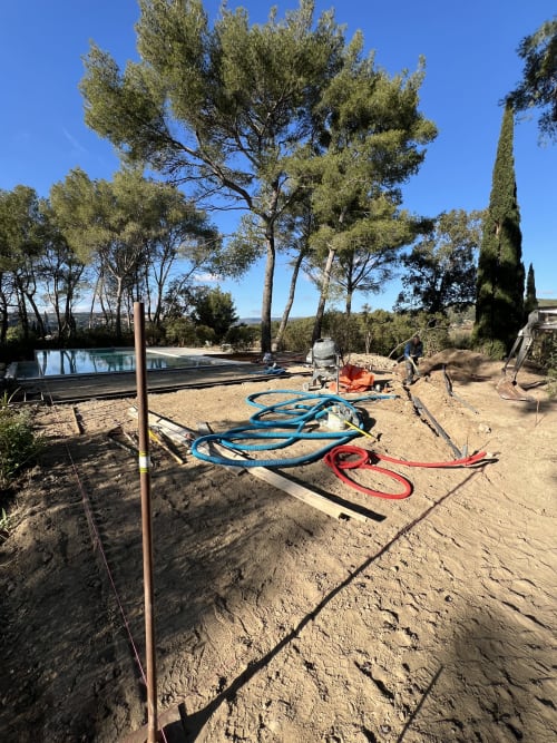 Chantier de construction de piscine au gîte Mas Misajail au Castellet avec tuyaux et équipements entre les pins