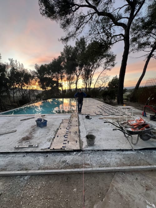 Piscine à débordement en construction au coucher de soleil, hôtel Mas Misajail au Castellet, France avec cyprès