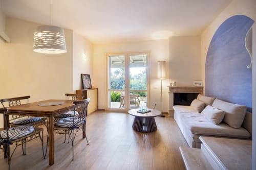 Luxurious villa living space in Quartu Sant'Elena with dining area, fireplace, and coastal views