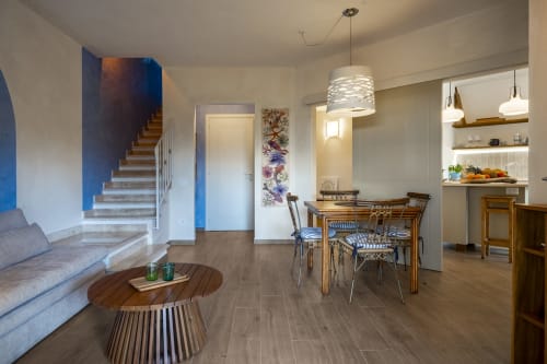 Modern open-plan living area at Top Villas Sardinia with dining table, sofa, staircase, and equipped kitchen in Quartu