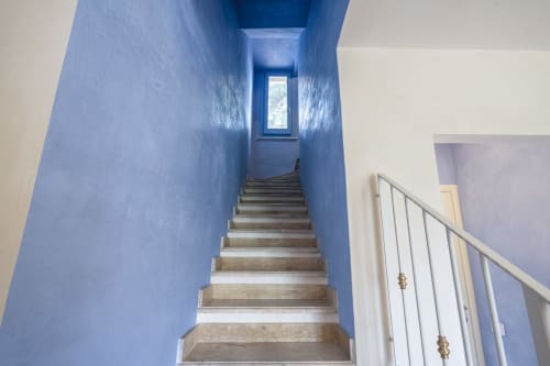 Blue stairwell with wooden steps and metal railing leading upward at Top Villas Sardinia, Quartu Sant'Elena