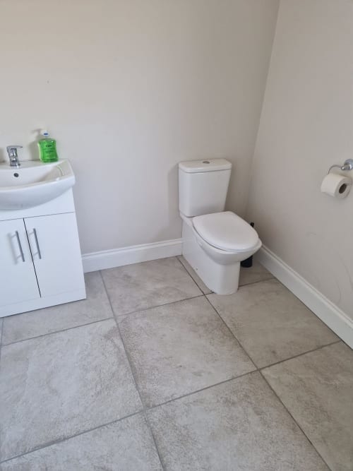 Clean bathroom with white sink, toilet, and tile flooring at Boswell Equestrian Centre apartment in Ashford, IE