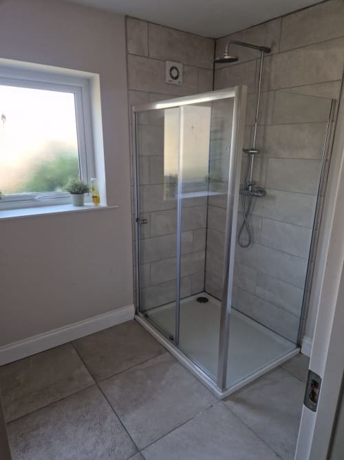 Modern shower enclosure with glass doors in bathroom at Boswell Equestrian Centre apartment, Ashford