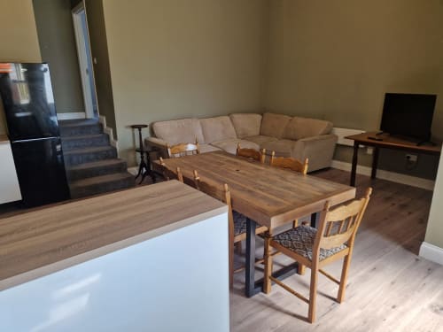 Open-plan living area at Boswell Equestrian Centre with kitchen, dining table and chairs, beige sofa, and TV in Ashford