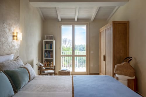 Bright bedroom at Top Villas Sardinia with sea views, wooden doors, bookshelf, and modern amenities in Quartu Sant'Elena