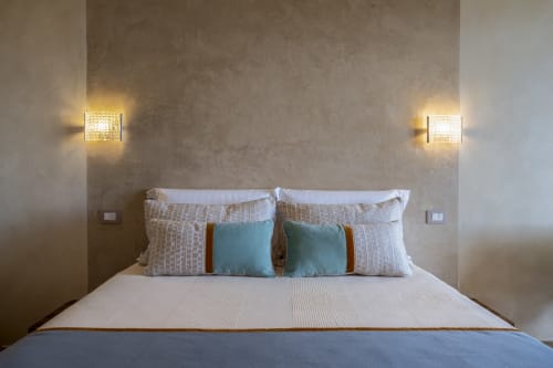 Modern bedroom at Top Villas Sardinia with bed, decorative pillows, and wall sconces in Quartu Sant'Elena