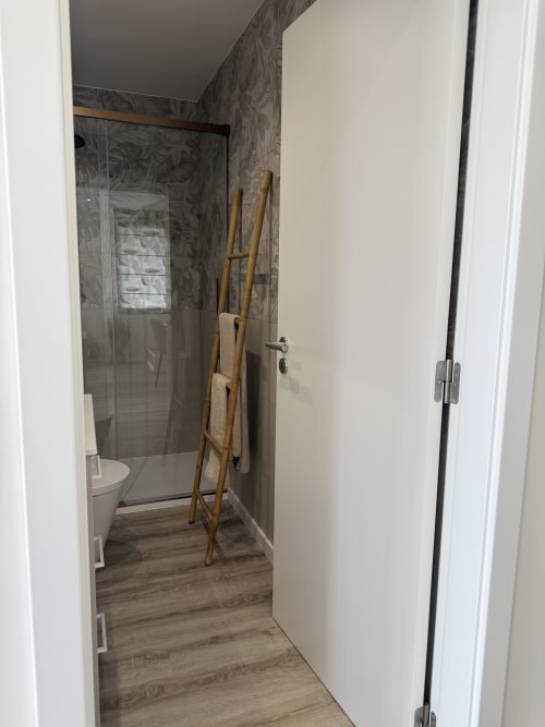 Casa Abadias em Vila Sotto Mayor: banheiro moderno com box aberto, toalheiro em madeira tipo escada e piso estilo madeira