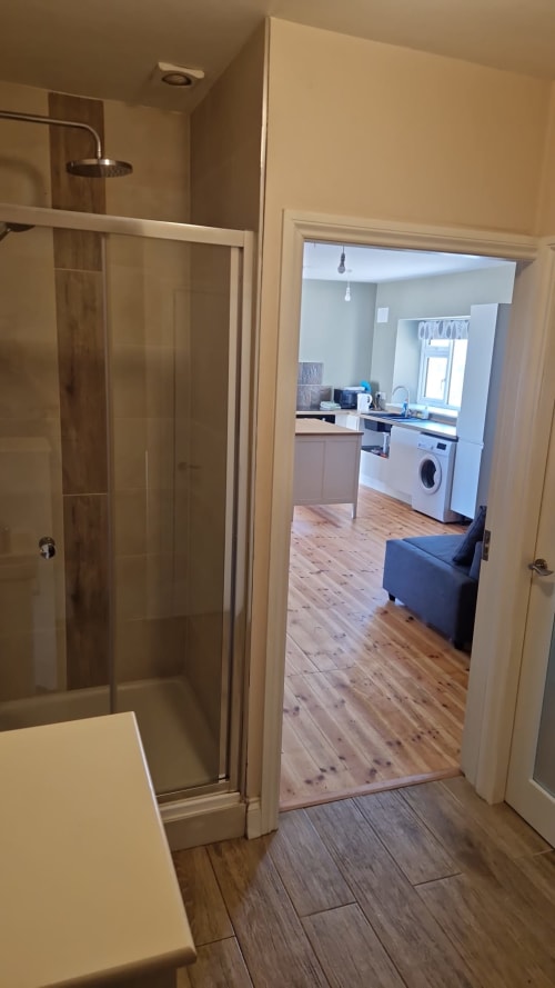 Bathroom with shower and view into kitchen of Apt 2 at Boswell Equestrian Centre, Ashford