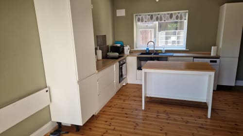 Modern kitchen in Apt 2 at Boswell Equestrian Centre, Ashford with white cabinetry, wooden countertops, and island