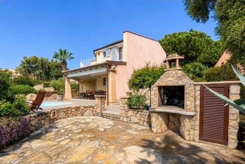 Luxury villa in Quartu Sant'Elena, Sardinia with stone terrace, outdoor fireplace, and pool area