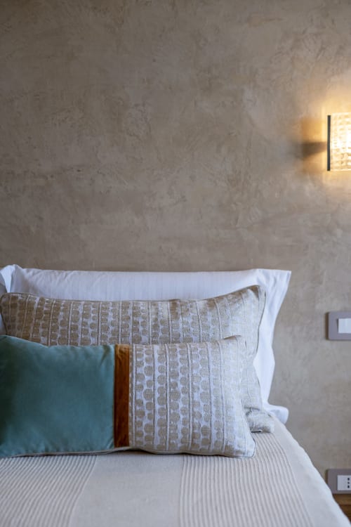 Comfortable bedroom with textured pillows and white bedding at Top Villas Sardinia villa in Quartu Sant'Elena