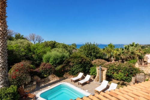 Villa Tigli terracotta rooftop with turquoise pool, loungers, Mediterranean garden, and Quartu Sant'Elena sea view