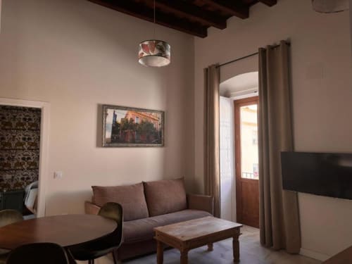 Acogedora sala de estar en el apartamento Top Home Integra de Jerez de la Frontera con sofá, mesa de madera y vistas a la ciudad
