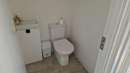 Modern bathroom in Studio apartment at Boswell Equestrian Centre with toilet, compact sink, and white walls