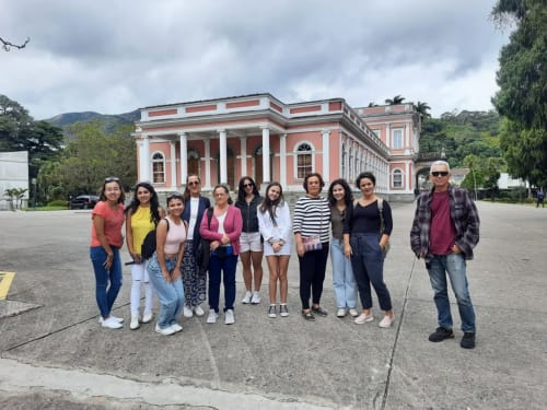 Grupo de hóspedes posando diante do icônico edifício colonial rosa da Rio Vibes Hostel no Rio de Janeiro