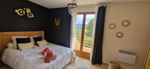 Chambre Bavella à Mare e Monti Vico avec vue montagne, lit en bois, mur d'accent sombre, balcon et équipements modernes