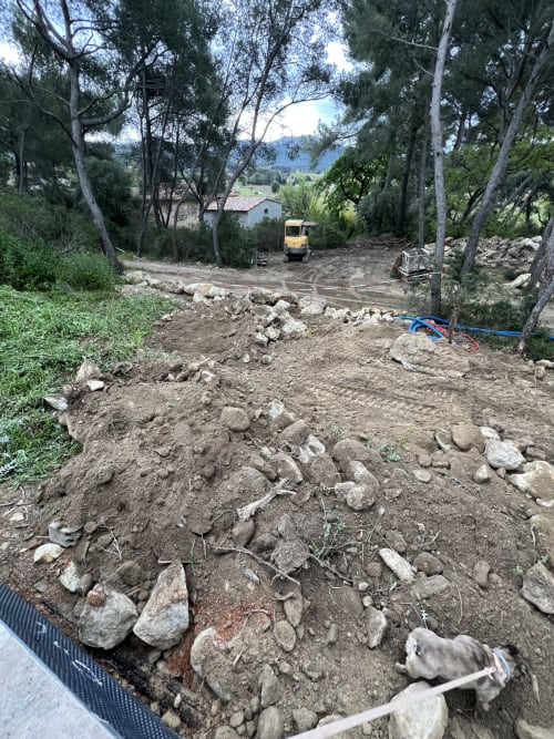 Chantier de construction au gîte Mas Misajail B&B au Castellet avec excavatrice jaune et arbres