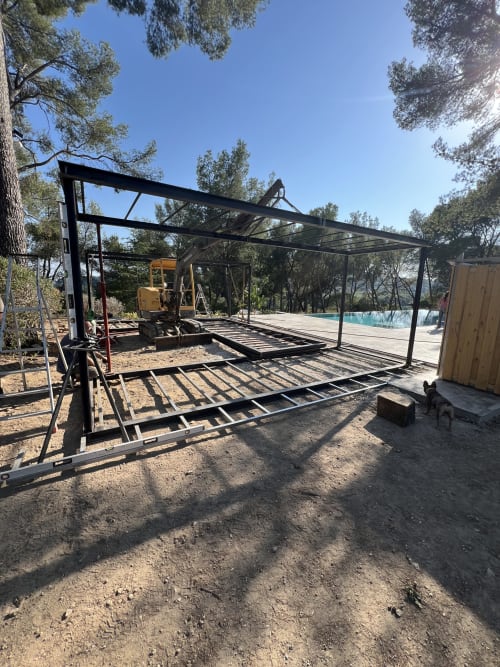 Structure de pergola noire en construction au Mas Misajail avec piscine visible à Le Castellet