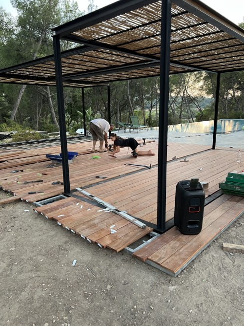 Homme faisant de l'exercice avec son chien sur la terrasse en bois sous la pergola du Mas Misajail, Le Castellet