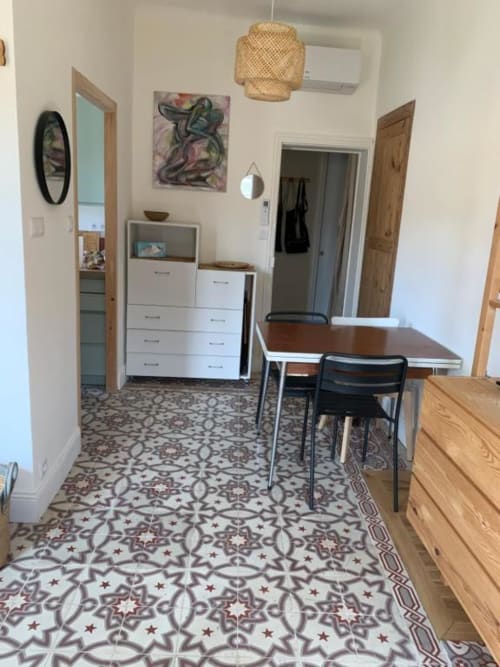 Salle à manger moderne avec carrelage à motifs, table en bois et rangements au Mas des Ecoliers en Provence