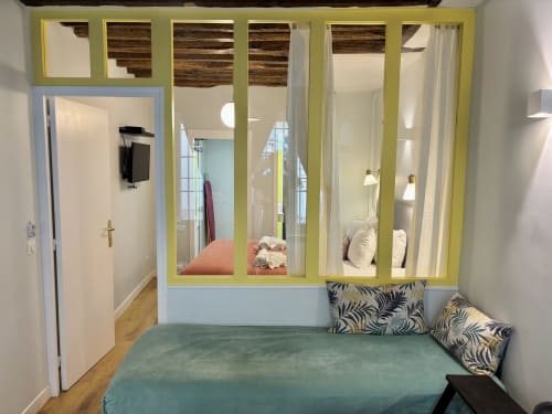 Dormitorio de apartamento parisino moderno con nicho acristalado, cama color turquesa y mobiliario contemporáneo en Odéon Saint