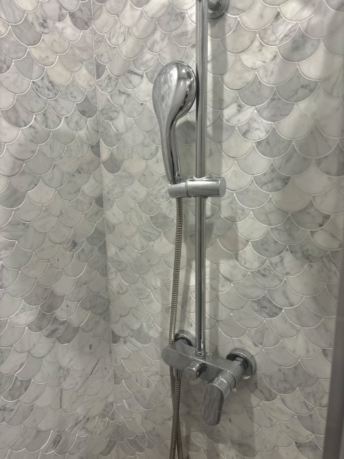 Ducha moderna con accesorios cromados y azulejos ondulados efecto mármol en el apartamento ALDARO París