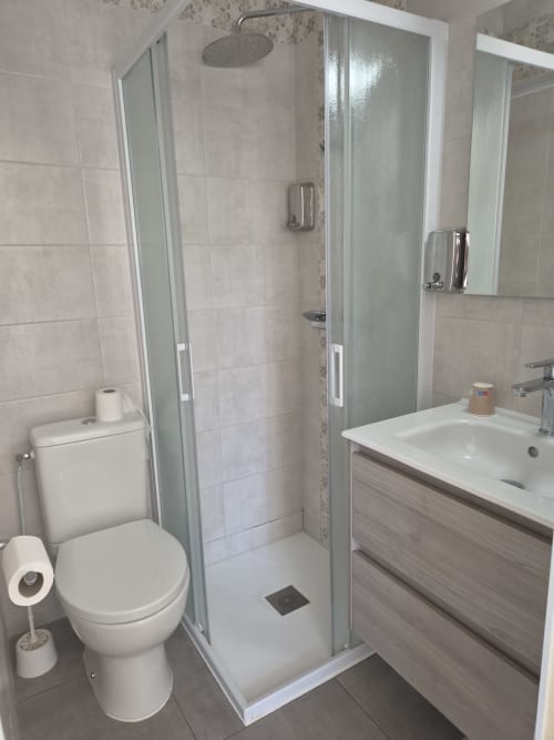 Salle de bain moderne avec douche, toilettes et meuble vasque à l'Hôtel Bar La Pinède, Saint-Jean-de-Monts