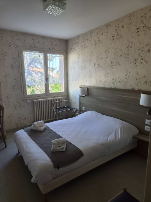Chambre double moderne à l'Hôtel Bar La Pinède à Saint-Jean-de-Monts avec lit queen-size, vue sur jardin et mobilier contemporain