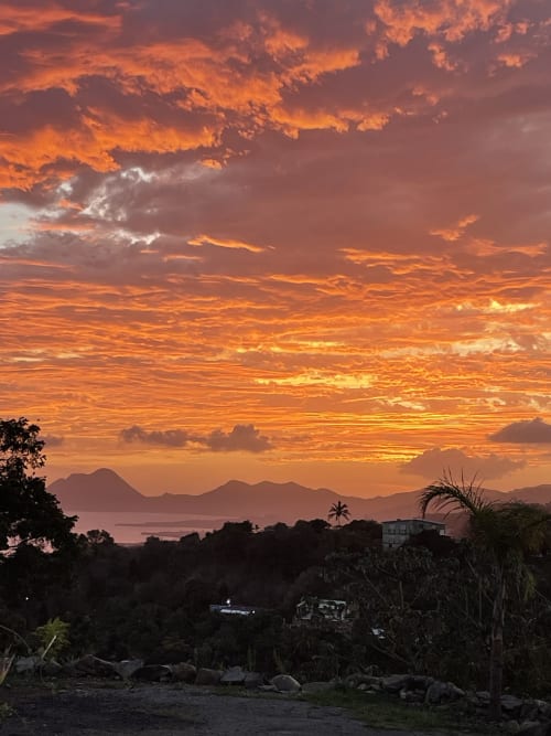 Coucher de soleil spectaculaire sur Le Marin, Martinique avec vue sur les montagnes et la mer depuis la Villa Chanté Grenouilles aux Terrasses du Morne