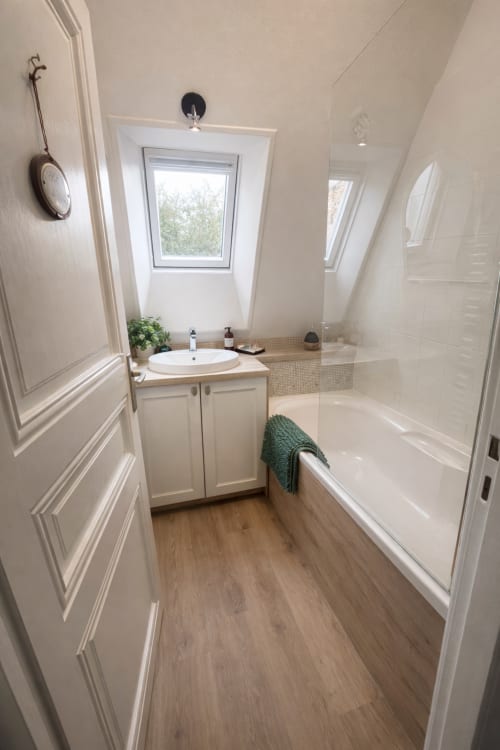 Salle de bains moderne de la Suite Maunoury à l'hôtel Maunoury Citybreak à Chartres avec vasque blanche, baignoire et fenêtre de toit