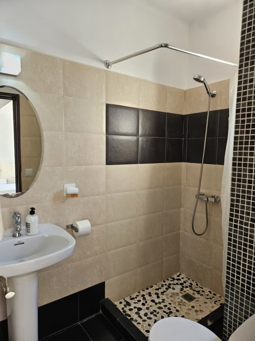 Baño moderno con azulejos beige y negro en Villa Palmer hostel de Paguera, España