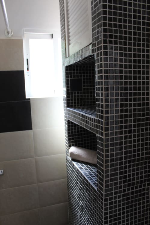 Moderna zona de ducha con azulejos de mosaico negro en Villa Palmer hostel, Paguera, España