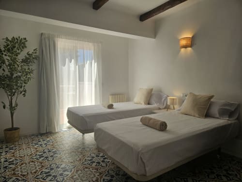 Luminoso dormitorio doble en Villa Palmer de Paguera con dos camas, acceso a balcón y comodidades modernas