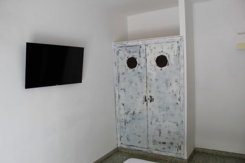 Armario de madera blanco con puertas dobles y televisor de pantalla plana en habitación del hostal Villa Palmer, Paguera