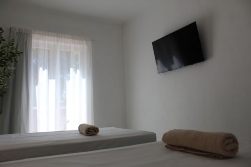Luminosa habitación doble en hostal Villa Palmer, Paguera, con toallas, TV de pantalla plana y acceso a balcón
