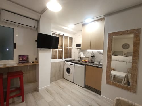 Cocina y sala de estar modernas en apartamento El Rincón de Sevilla, Sevilla, con lavadora, cocina y TV de pantalla plana