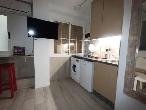 Cocina-salón moderno en apartamento El Rincón de Sevilla, Sevilla, con electrodomésticos blancos, TV y distribución abierta
