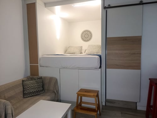 Moderno estudio en El Rincón de Sevilla con cama elevada, sofá y armario corredizo