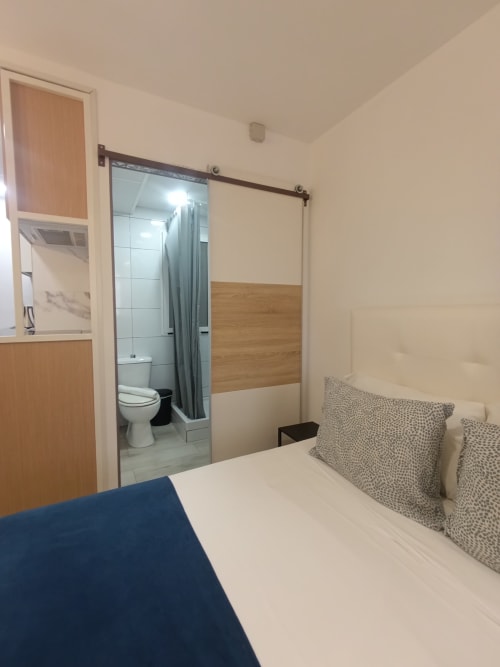 Dormitorio moderno en apartamento El Rincón de Sevilla con baño privado, puerta corredera y vistas a la ciudad, Sevilla España