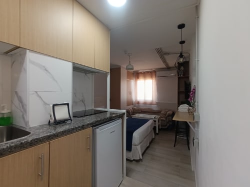 Moderno estudio en Sevilla con cocina americana, cama, zona de estar y vistas a la ciudad cerca del centro metro