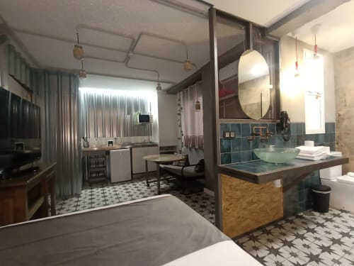 Vista abierta del baño y cocina del apartamento El Rincón de Sevilla con acabados modernos, detalles en azulejos verde azulado e acero inoxidable