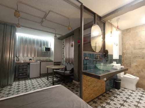 Estudio moderno de planta abierta en El Rincón de Sevilla con dormitorio, baño con lavamanos de vidrio, cocina y zona de trabajo