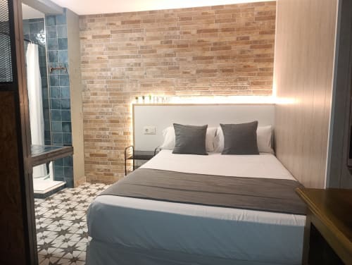 Dormitorio moderno en El Rincón de Sevilla con pared de ladrillo, cama queen y baño privado