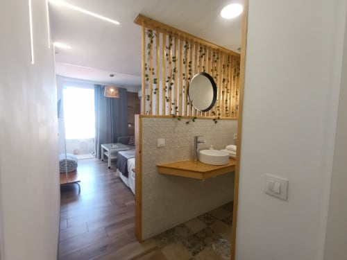 Baño moderno de estudio con tocador de madera y panel decorativo, apartamento El Rincón de Sevilla, Sevilla