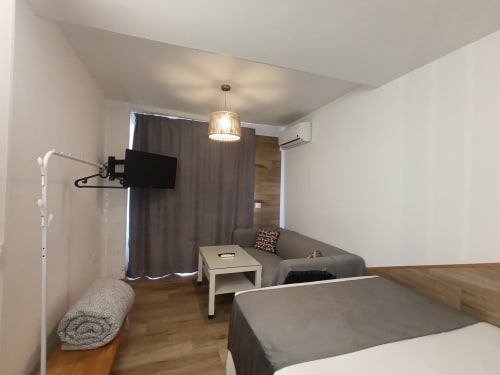 Moderno estudio en Sevilla con cama, sofá, TV y cocina americana cerca del centro del metro