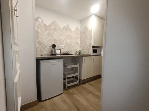 Cocina moderna en El Rincón de Sevilla con azulejos espiga, frigorífico blanco, microondas y granito