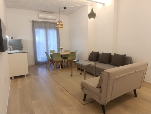 Moderna sala de estar en El Rincón de Sevilla con sofás, mesa de comedor, cocineta y lámparas colgantes
