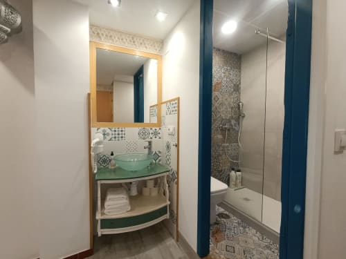 Baño moderno con lavamanos verde, azulejos con patrón y ducha abierta en el apartamento El Rincón de Sevilla, Sevilla