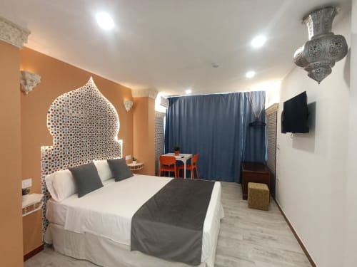 Dormitorio moderno en El Rincón de Sevilla, Sevilla con cama blanca, cabecera marroquí, televisor y zona de descanso