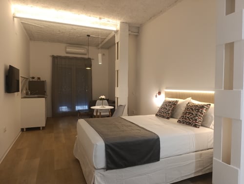 Moderno dormitorio en el apartamento El Rincón de Sevilla en Sevilla, España, con cama queen y almohadas estampadas, iluminación LED